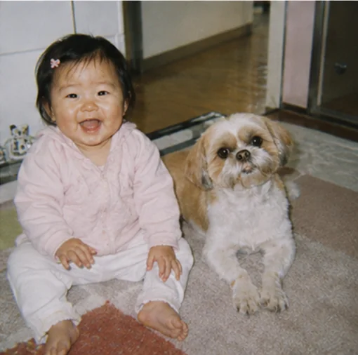 愛犬と並んで笑う幼いはるかさん